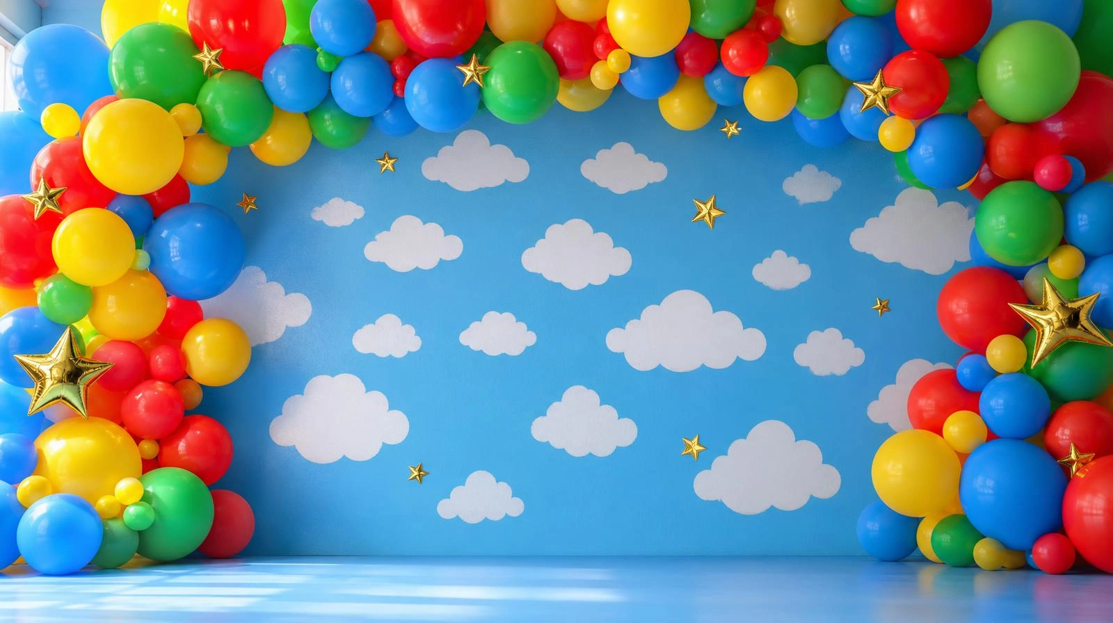 Toy Story party decorations featuring a white cloud backdrop on blue with a primary-color balloon garland and star accents.